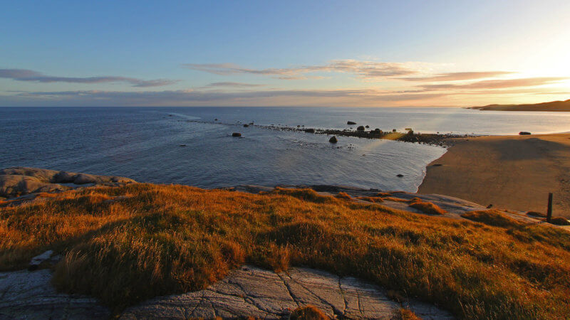 A line of tidal rocks, seen at sunset, disappears in to the Barents Sea.