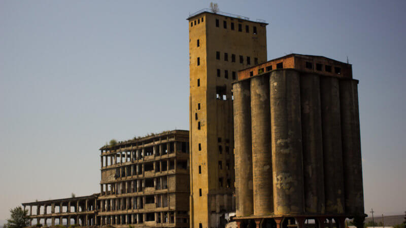 Far shot of four disused Soviet-era buildings.