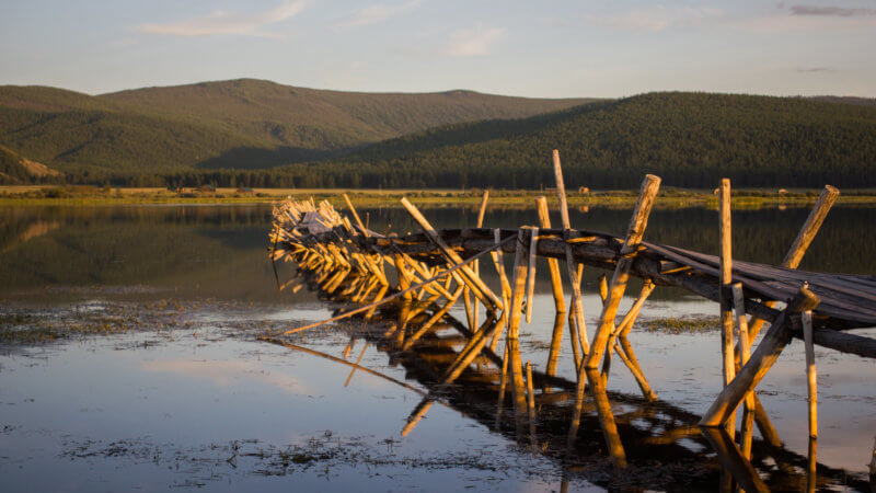 A bridge made of logs slowly sinking into the silt of Huun Huur Tu lake.