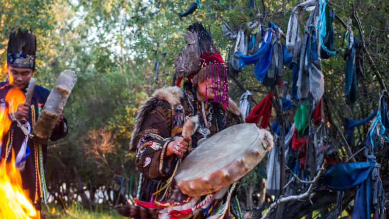 A mid-shot of a Tuvan shaman conducting a traditional fire ceremony outside of Kyzyl.