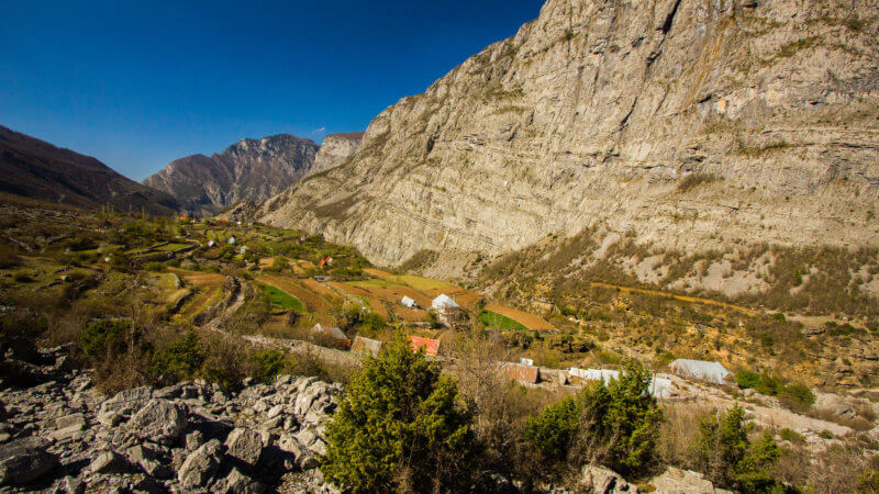 Wide mountain valley next to giant cliffs in Albania.