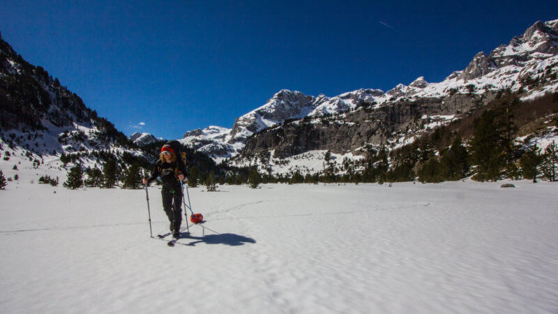 A skier tows his bag through a snow covered plateau.