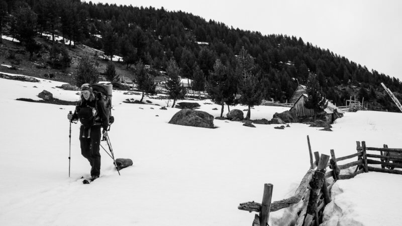 Black and white photo of lone skier in abandoned mountain village.