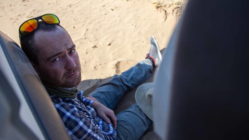 Photographer Mark Woodward on a rest break in the Saryesik-Atyrau desert in Kazakhstan.