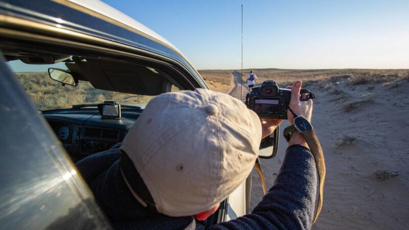 Photographer Mark Woodward filming from a 4x4 vehicle in the Saryesik-Atyrau Desert.