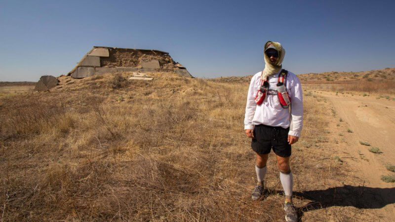 English runner Jamie Maddison pauses for a photo next to the unknown remains of a Soviet-era engineering project in Kazakhstan's Saryesik-Atyrau Desert.