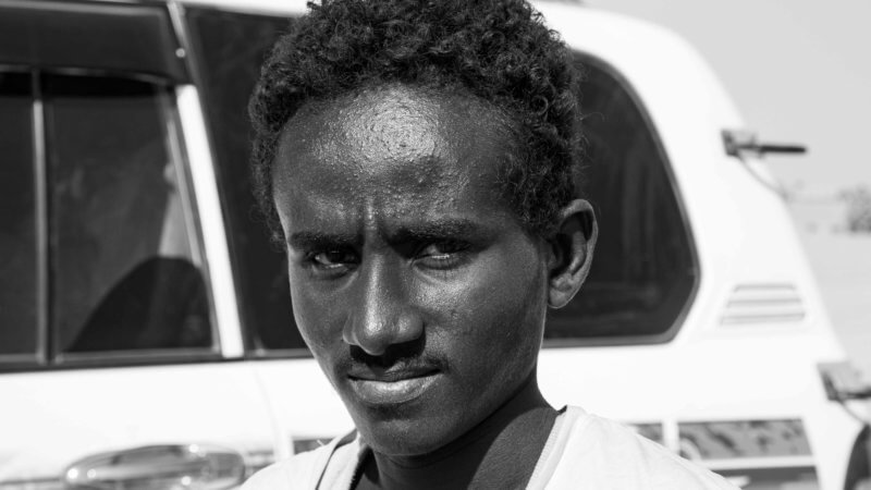 Black and white portrait of Afar teenage guide in Danakil Depression.