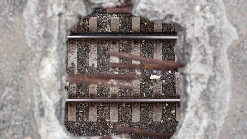 Train tracks framed through a square crack in a bridge in Georgia, Caucasus.